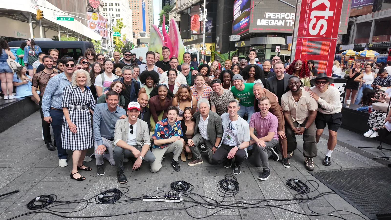 Current and former Little Shop of Horrors cast members and creatives pose together in Times Square