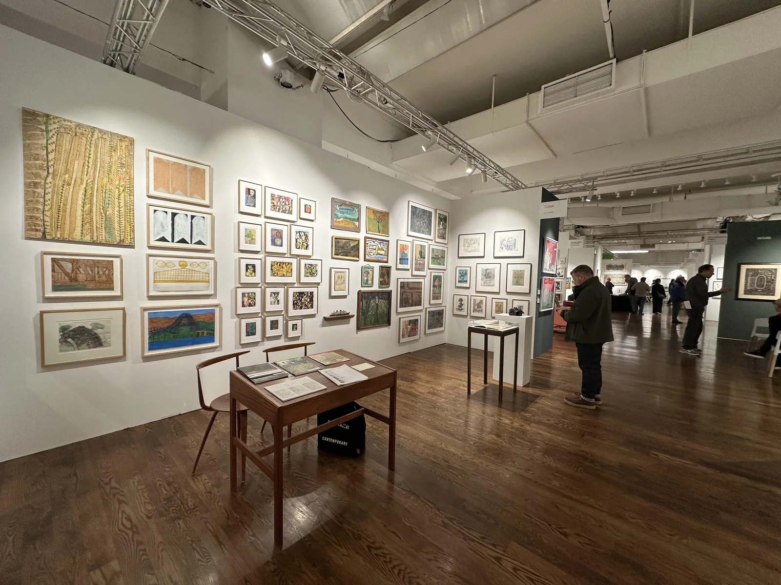 Visitors move among densely installed gallery booths at the Metropolitan Pavilion