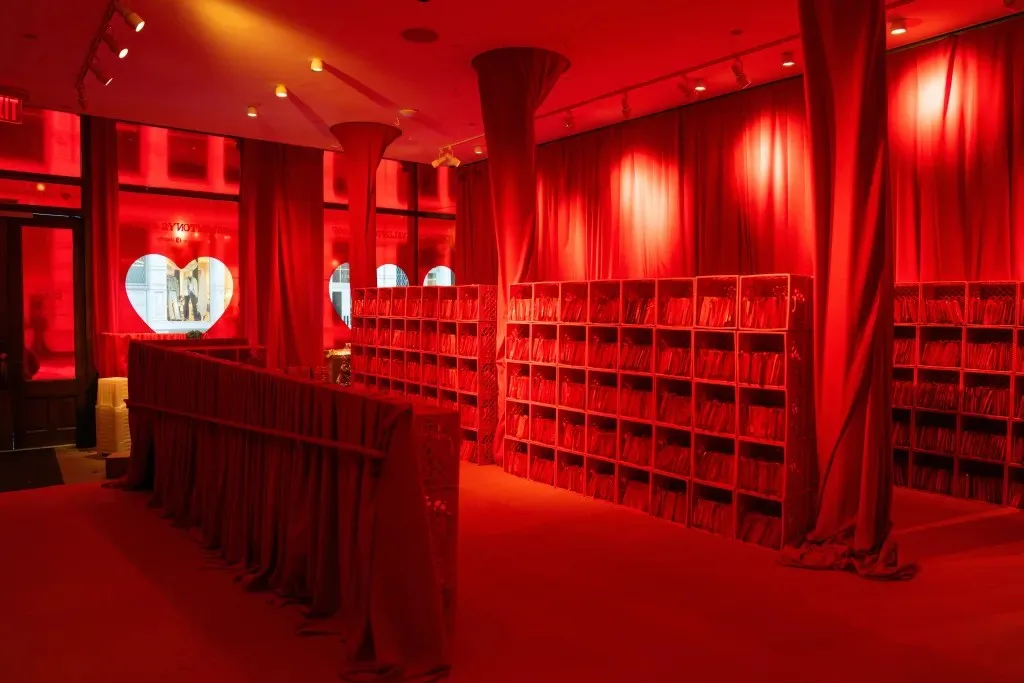 Red shelves filled with mystery bags line the all-red Valentony's Shop installation