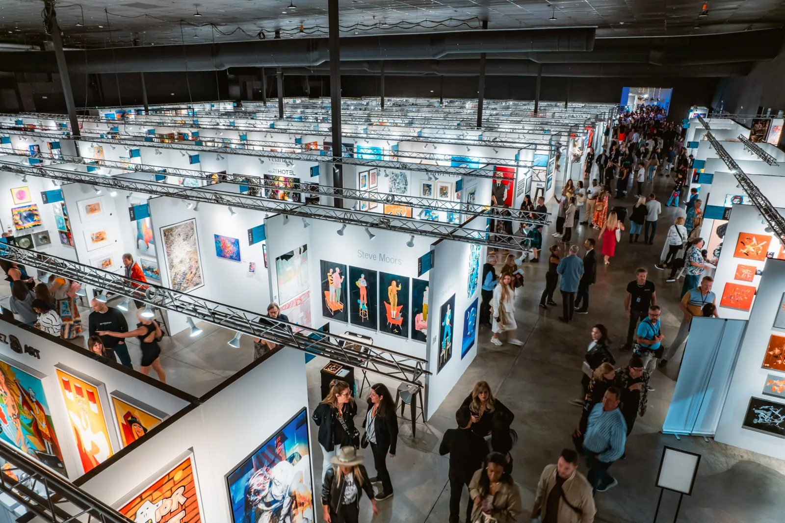 Visitors move through the art-fair aisles inside Mana Wynwood