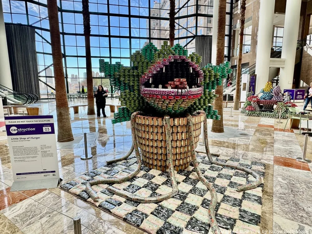 A large green monster sculpture built from canned food stands in Brookfield Place