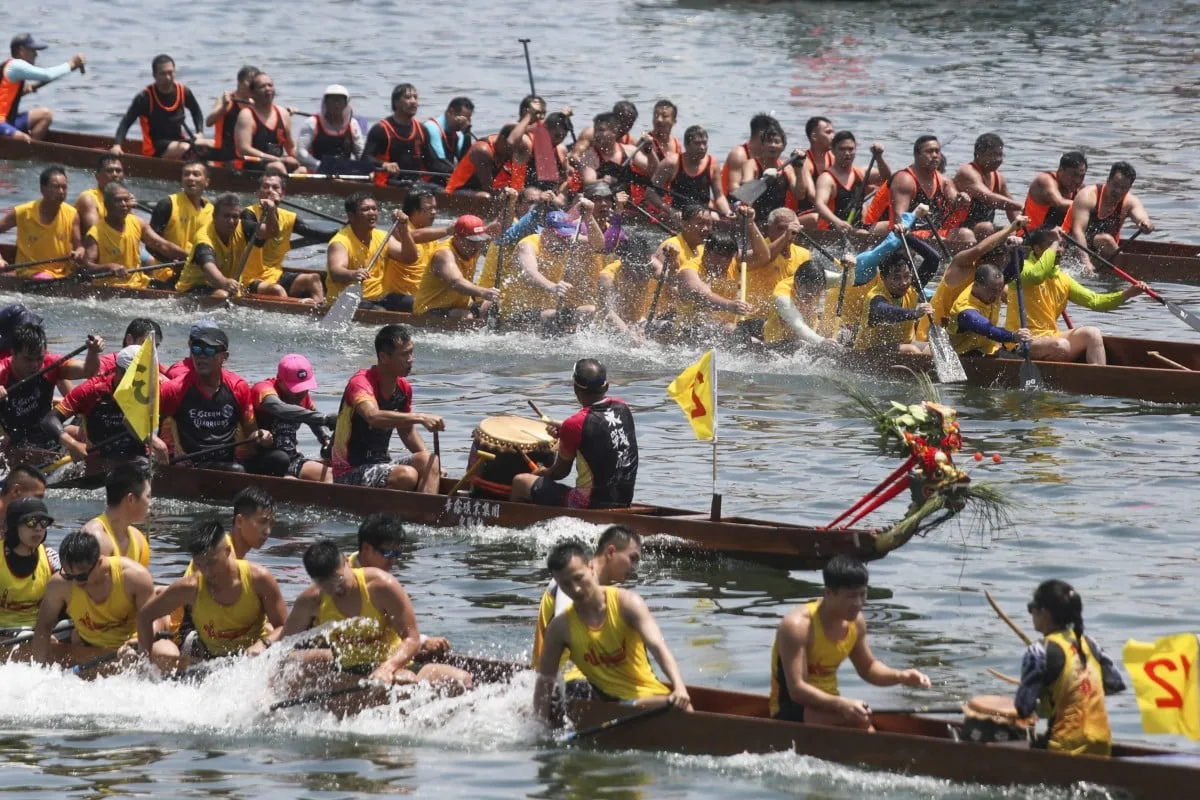 Several dragon boat teams paddle side by side across Meadow Lake as drummers keep time