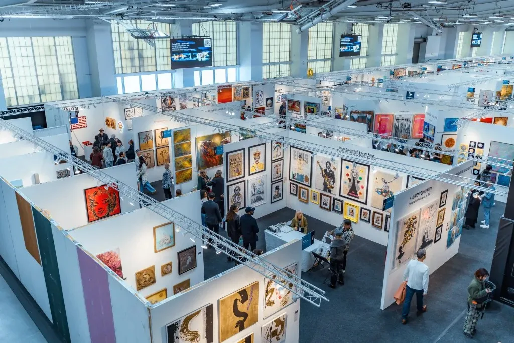 A high view shows rows of gallery booths across the Artexpo New York fair floor