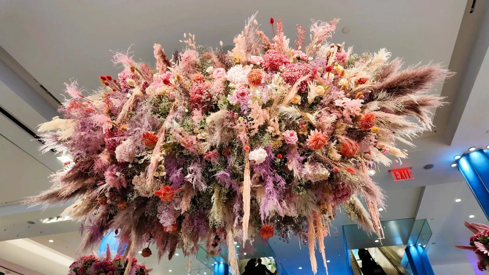 A dense cloud of pink, cream, and burgundy flowers hangs above the store floor