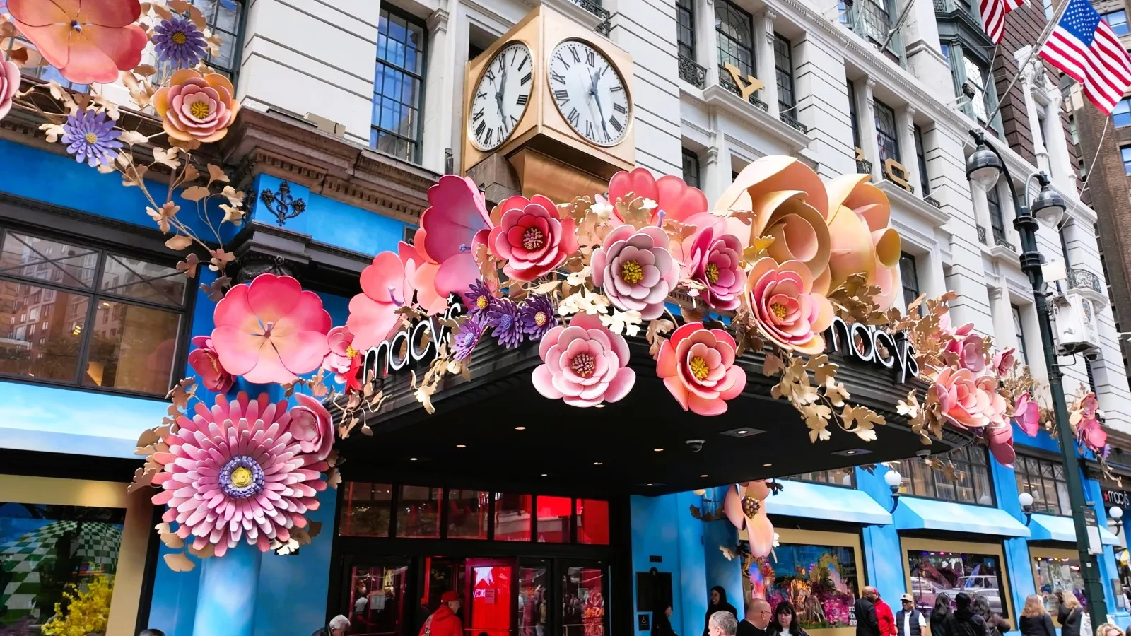 Oversized pink flowers cover the Macy's Broadway entrance beneath its clock
