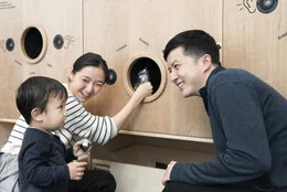Photo: Martin SeckImage description: Parents and young child listing to the sounds materials make at the Listening Wall in Art Lab: Sound.