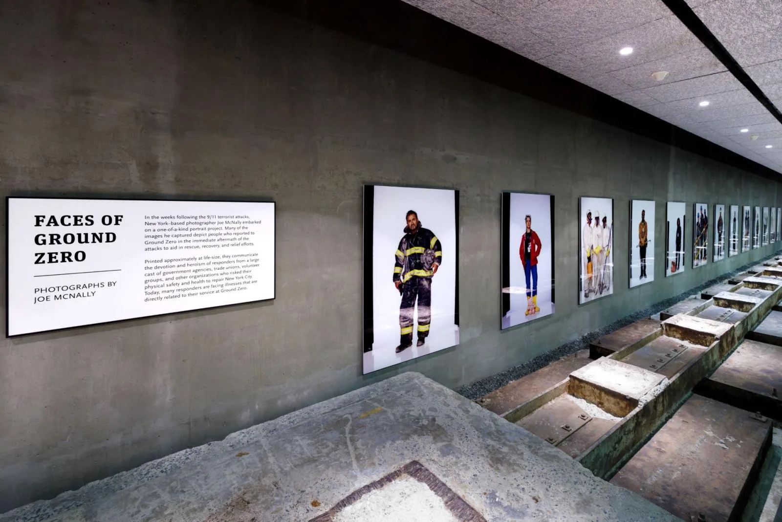 A cement hallway with large photos visible down the wall